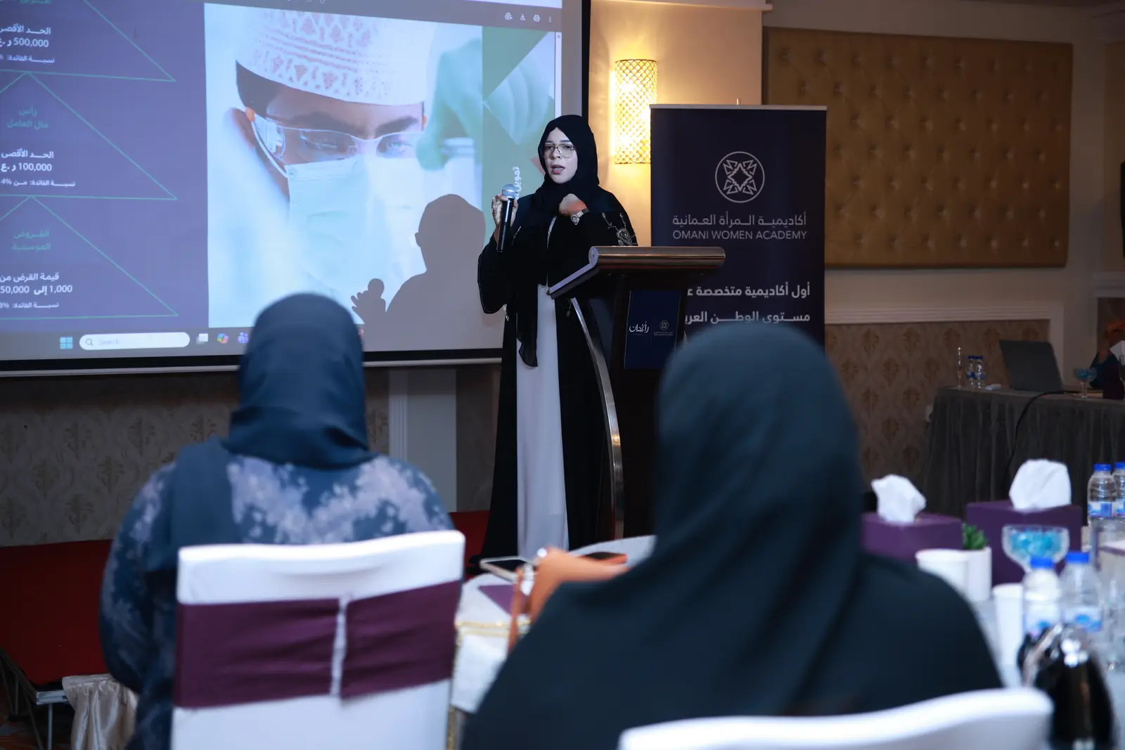 قيادية عمانية تلقي كلمة من على المنصة أمام الحضور